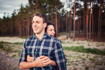 young couple smiling at each other during a romantic date in the forest