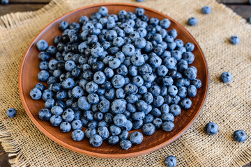 Fresh berries of blueberry on a plate. It can be used as a background