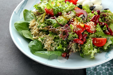 Plate with tasty quinoa salad on table, closeup