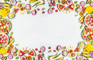 Fototapeta na wymiar Variety of slices fruits on white background. Colorful fresh fruits. Flat lay, top view, copy space. Summer food