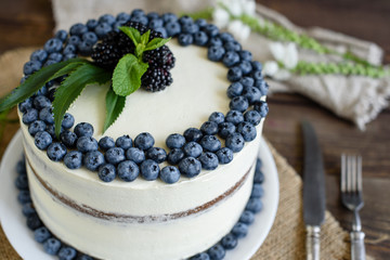 Beautiful tasty cake with white cream and berries of blueberry