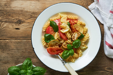 Pasta with tomatoes, zucchini and basil in a bowl