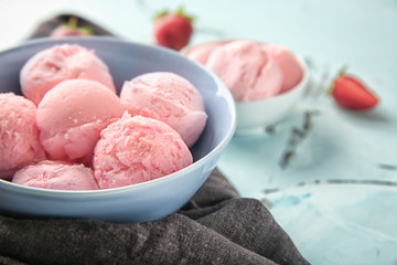 Bowl with delicious strawberry ice-cream on color table