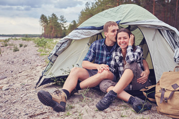 Couple camping. Young people sitting in tent