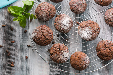 Cooling rack with delicious chocolate cookies on wooden table