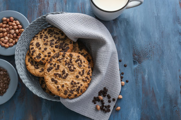 Delicious cookies with chocolate and cup of milk on color wooden background