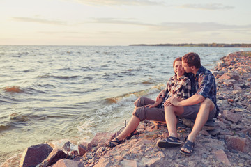 stylish hipster couple kissing at lake. man and woman embracing, in love relaxing in summer park, picnic date.
