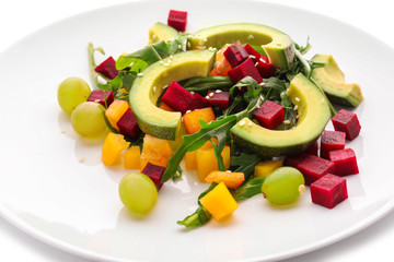 Plate with tasty avocado salad on white background, closeup