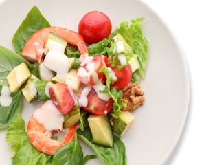 Plate with tasty avocado salad on white background