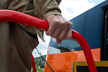 barrierefreies Reisen, festhalten an Geländer von Hebelift am Reisebus