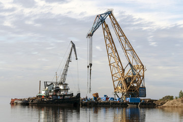Fototapeta premium Floating cranes loaded goods on the water