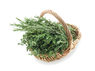 Wicker basket with fresh herbs on white background