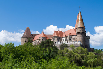 Fototapeta premium Corvin Castle through the trees outside Hunedoara, Romania