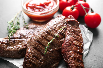 Tasty grilled meat with thyme on table
