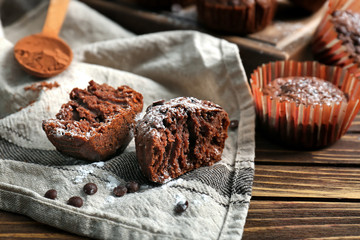 Tasty chocolate muffins on wooden table