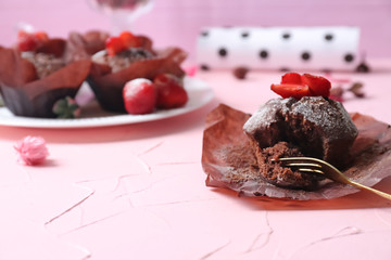 Tasty chocolate muffin on color table