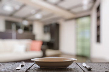 empty plate with fork and knife on wooden table