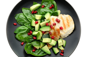 Salad with ripe avocado on plate against white background