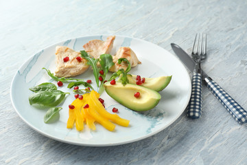 Plate with tasty avocado salad on table