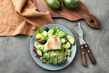 Plate with tasty avocado salad on table