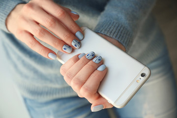 Young woman with beautiful manicure holding phone, closeup