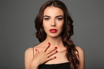 Young woman with beautiful manicure on grey background