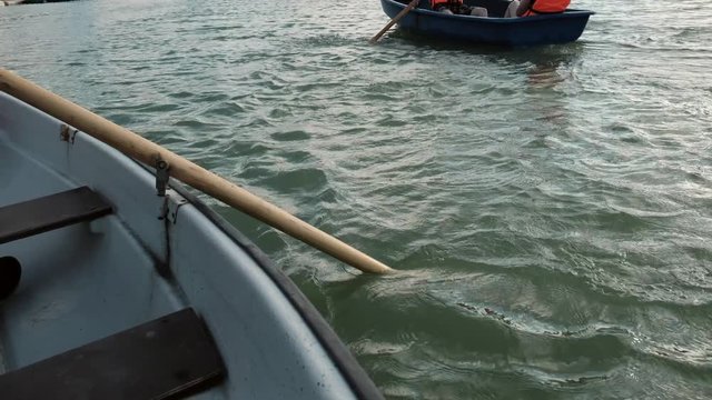 Man paddles oars. Boat sailing along the lake. boating. Vacation, tourism, leisure, activity concept. Slow motion