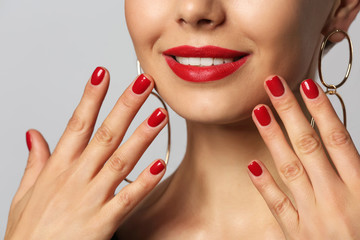 Young woman with beautiful manicure on grey background, closeup