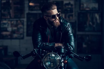 Foto op Plexiglas Young Biker in Sunglasses on Motorcycle in Garage. © VadimGuzhva