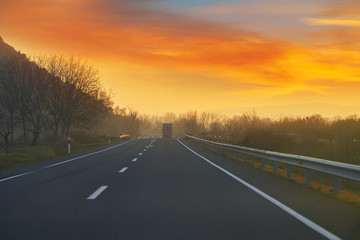 Fototapeta na wymiar Sunset on the road with golden sky