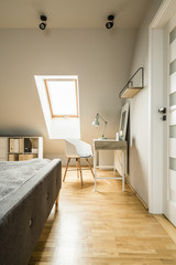 White chair at desk with lamp in home office interior in the att
