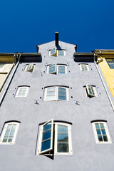 Fototapeta na wymiar Old beautiful European building with old windows against the blue sky. View from below. Architecture. Europe. Travels.