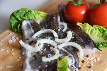 Fototapeta na wymiar raw fish fillet with tomatoes, spices and onions