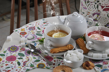 various cookies and biscuits baked at home in a container and tea in a retro cup with free space for text