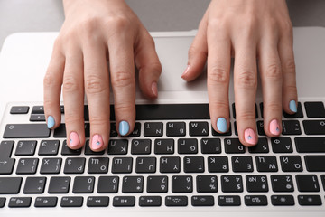 Fototapeta na wymiar Woman with stylish color nails using laptop, closeup