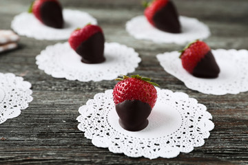 Delicious strawberries covered with chocolate on wooden table