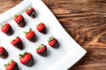 Strawberries covered with chocolate on plate
