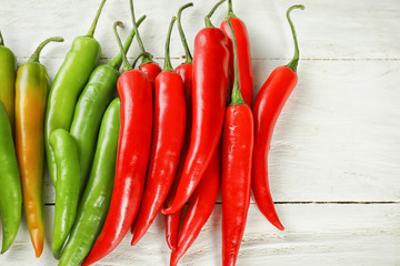Chili peppers on white wooden background