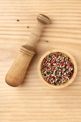 An overhead photo of a mix of various peppers with a pestle, with copy space
