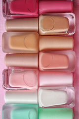 Bottles of colorful nail polishes on wooden background