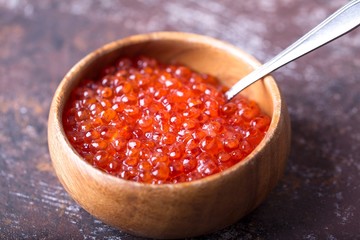 Tasty red caviar in wooden bowl