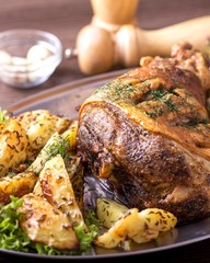 Roast pork knuckle with garnish. Tasty roasted knuckle with  potato