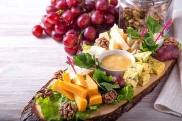 Cheese plate with nuts, honey and red grape