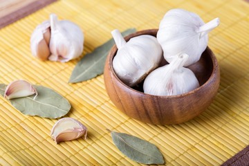 Garlic cloves and bulb in  wooden bowl.   Spices