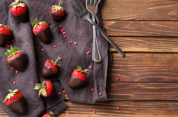 Tasty chocolate dipped strawberries on wooden background