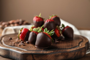 Board with tasty chocolate dipped strawberries on table