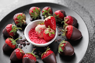 Plate with tasty chocolate dipped strawberries on table, closeup