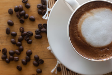 hot coffee in cup and coffee bean On the wooden table
