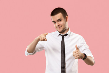The happy businessman standing and smiling against pink background.