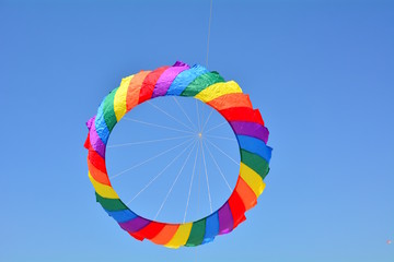 A circular colorful kite flying in the sky - 214619718